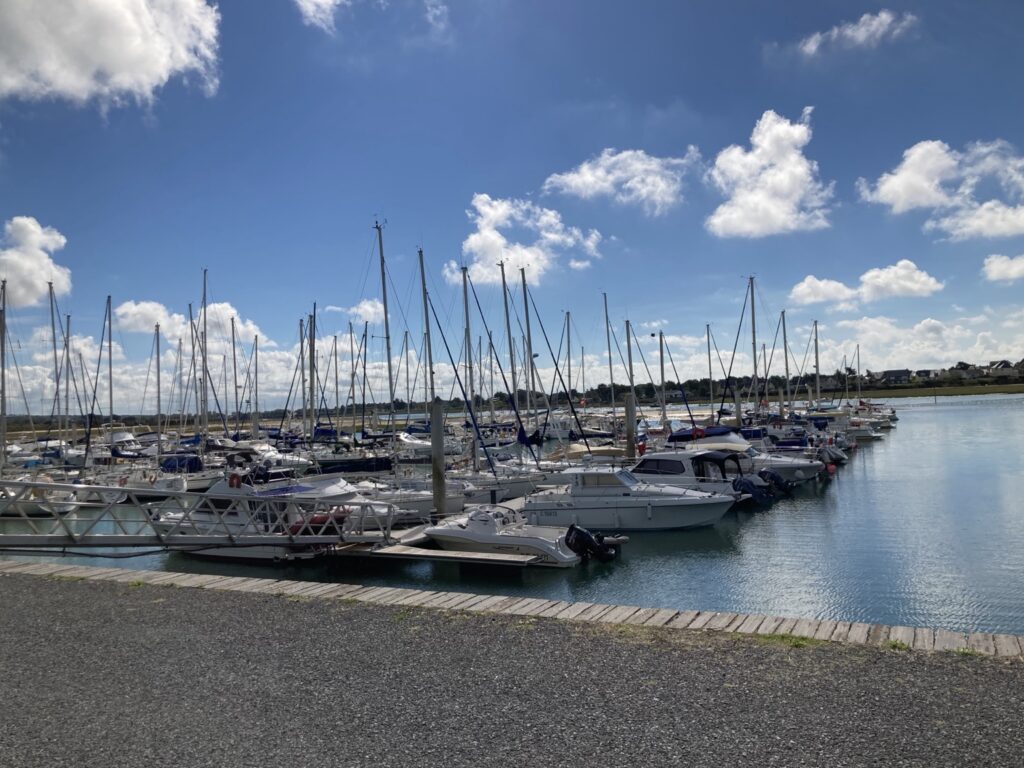 Vue panoramique du port de plaisance de Carteret avec ses voiliers amarrés sous un ciel bleu en Normandie.